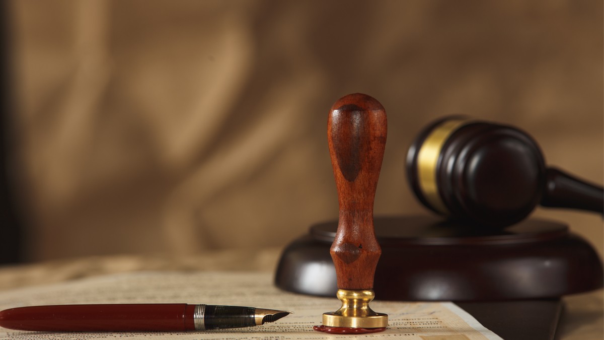 A wax seal stamp and gavel on a legal document